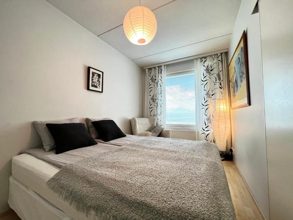 a bedroom with a large bed with a window at Cozy flat in Suurpelto in Espoo