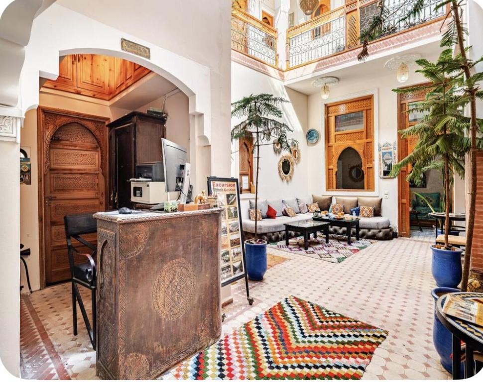 un grand salon avec un comptoir et un salon dans l'établissement Riad Jenan Adam, à Marrakech