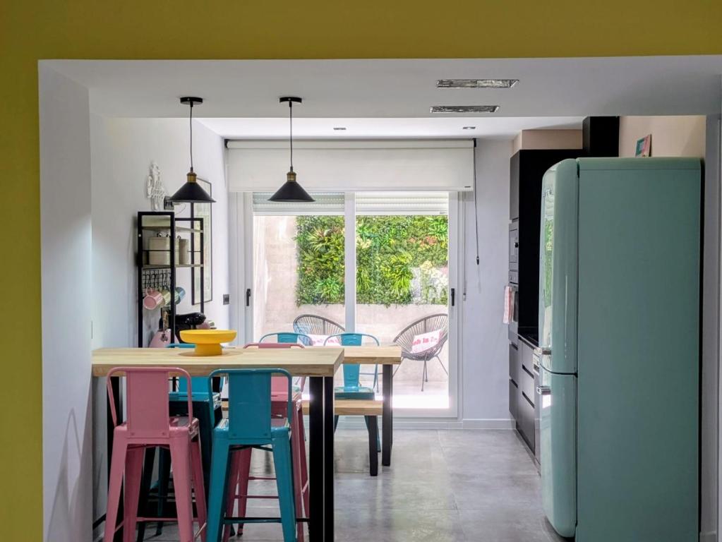 a kitchen with a table and chairs and a refrigerator at El Taller de San Martín in Águilas