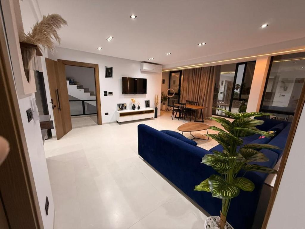 a living room with a blue couch and a tv at Appartement neuf S2 in Nabeul