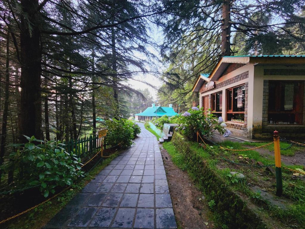 ダルハウジにあるForest Vibes Kalatop-Rooms And Restaurantの木々のある家の前の歩道