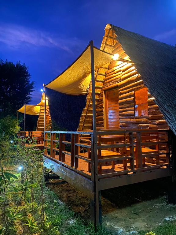 a wooden cabin with a thatched roof at night at Phu Aunna in Ko Phayam