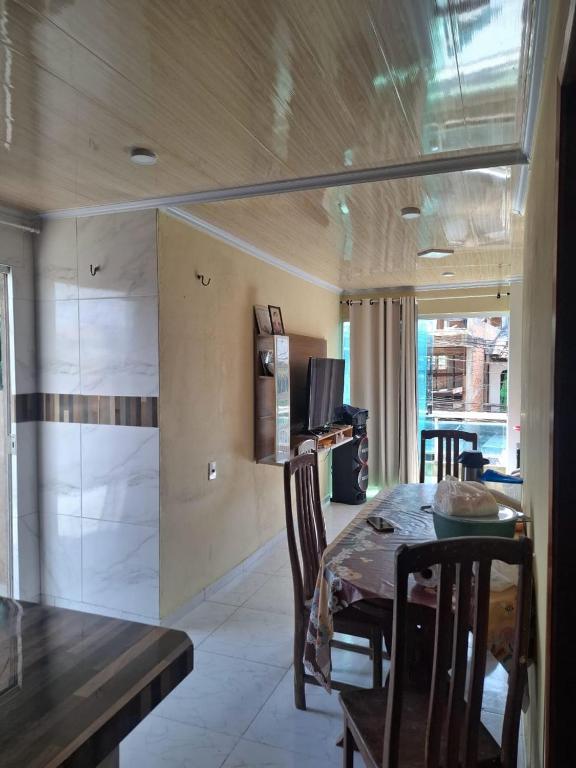 a dining room with a table and a kitchen at Apartamento cop 30 Belém in Belém