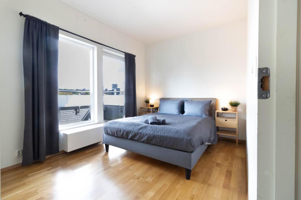 Un dormitorio con una cama y una ventana grande. en Modern Room in shared apartment with a Beautiful Private Balcony, en Oslo