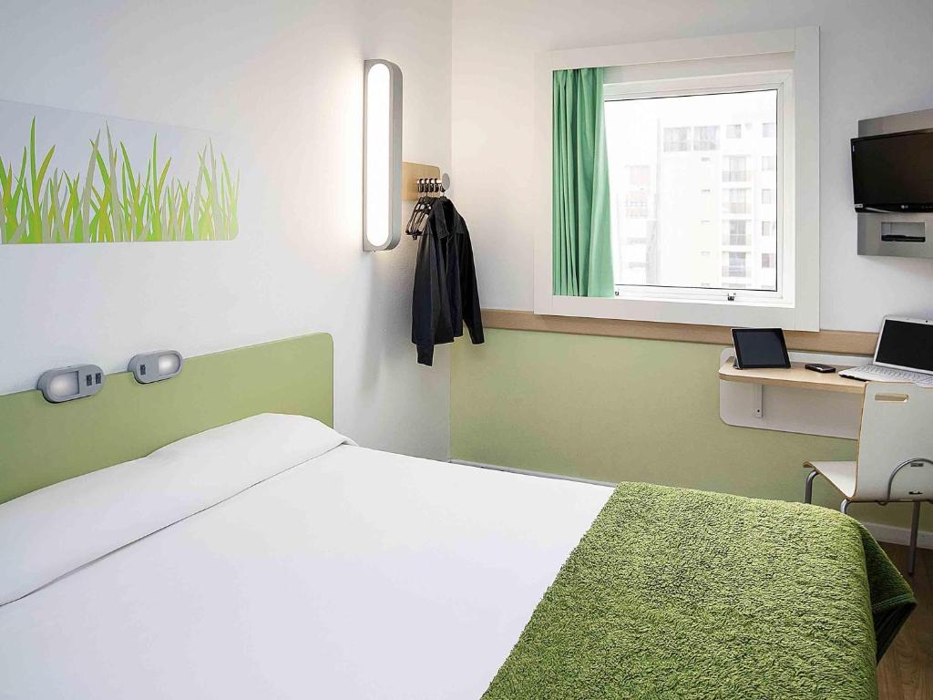 a bedroom with a bed and a desk and a window at ibis budget Sao Paulo Paraiso in Sao Paulo