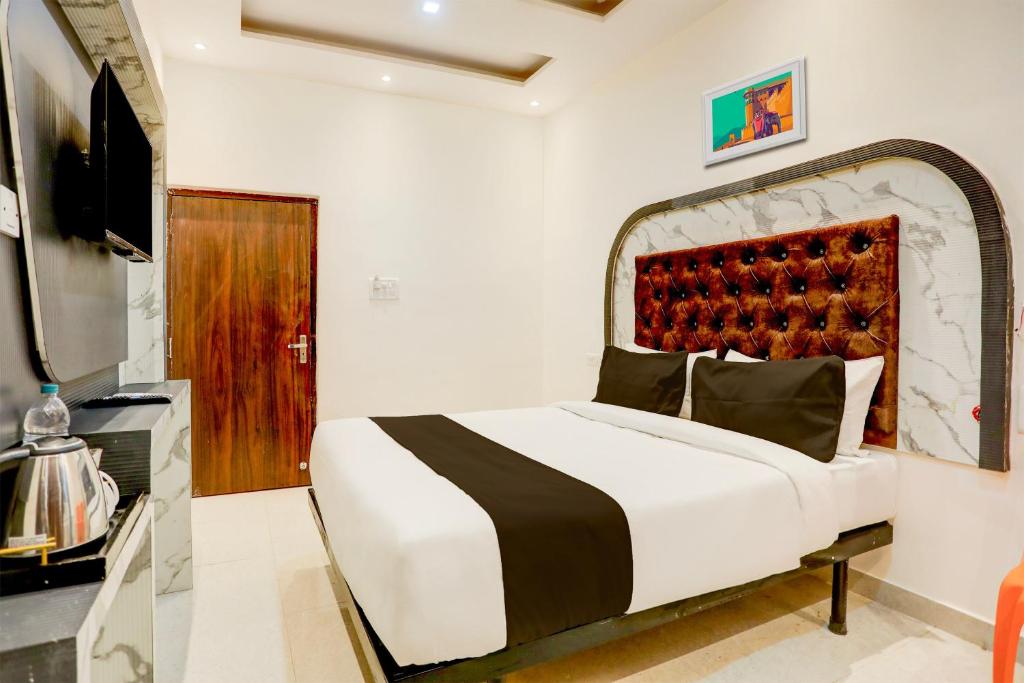 a bedroom with a large bed and a television at Super Hotel O SHIVA VALLEY HOTEL in Varanasi
