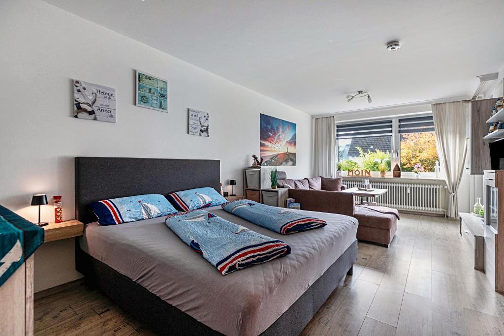 a bedroom with a large bed and a living room at Kleine Auszeit am Meer in Büsum