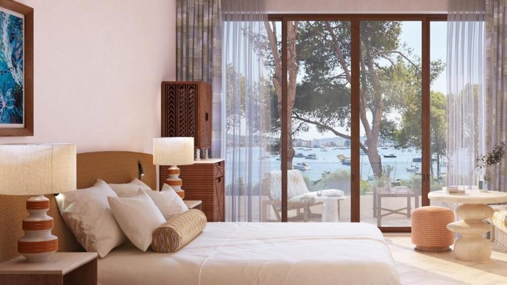 ein Schlafzimmer mit einem Bett und einem großen Fenster in der Unterkunft Mandarin Oriental Punta Negra, Mallorca in Palmanova