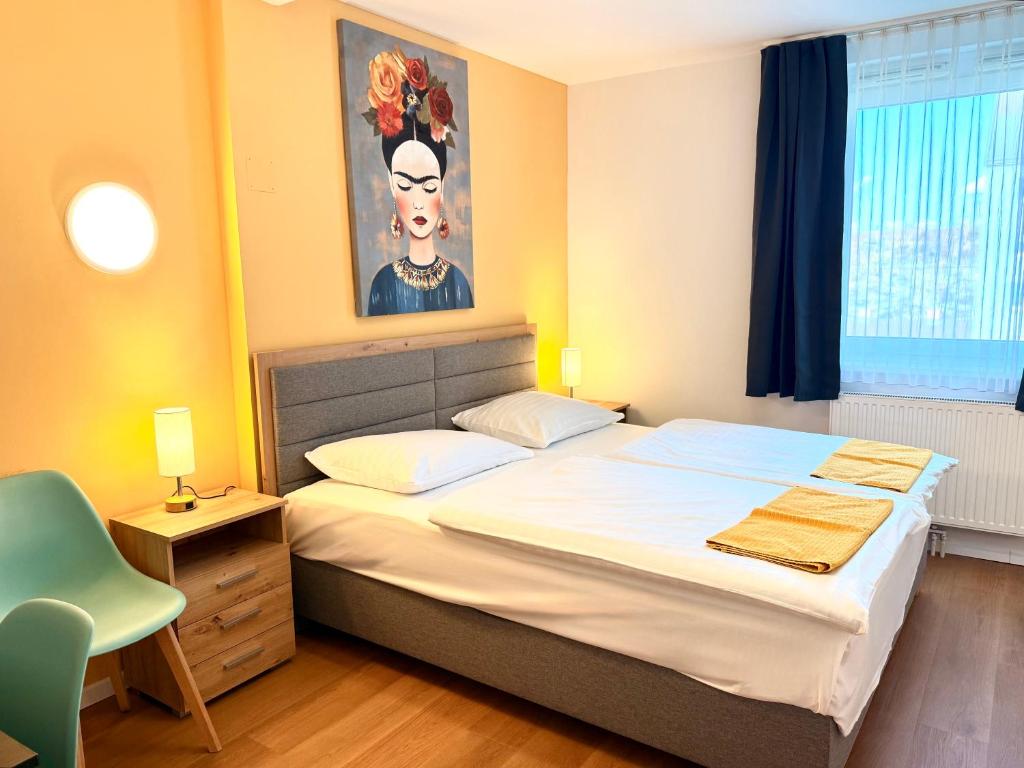a bedroom with a bed with a painting on the wall at A&T Hotel & Hostel in Vienna