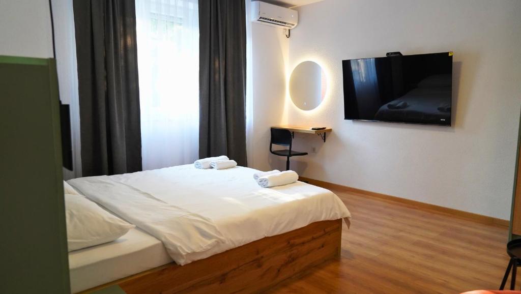 Un dormitorio con una cama y un televisor de pantalla plana. en Meet Prishtina Apartment, en Pristina