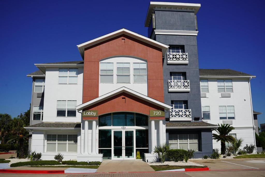 a large building with white and red at Candlewood Suites Houston Space Center - Webster in Webster