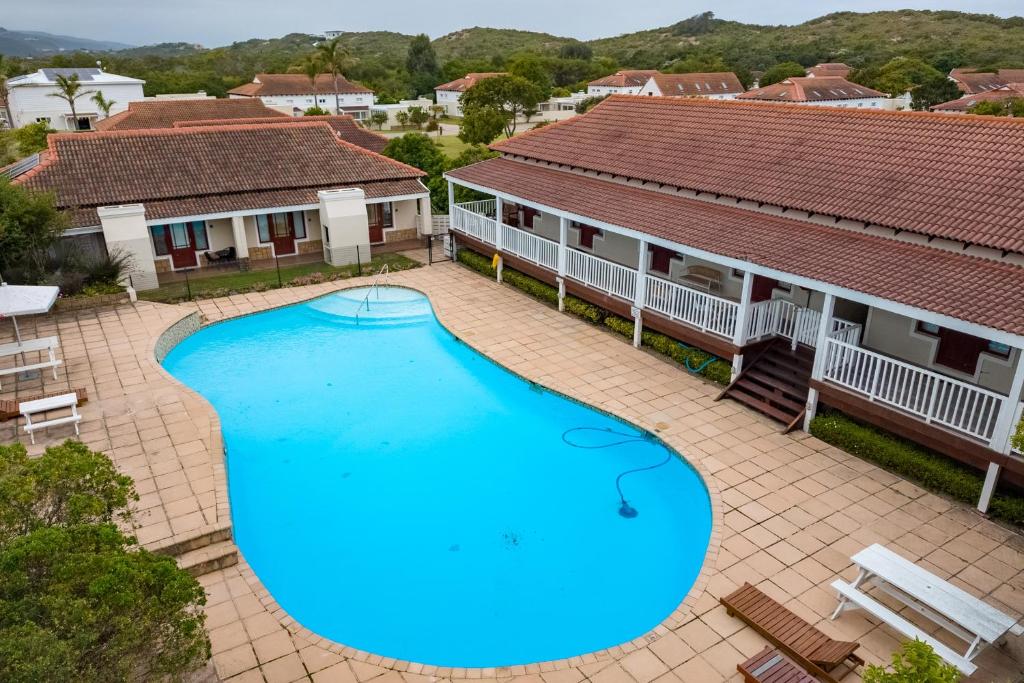 an overhead view of a large swimming pool in front of two buildings at Dune Sanctury in Keurboomstrand