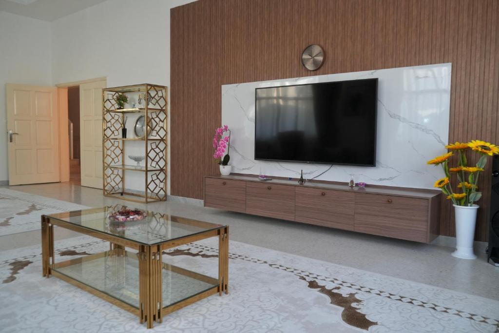 sala de estar con TV y mesa de centro en Oasis Villa Stay by Lunar, en Abu Dabi