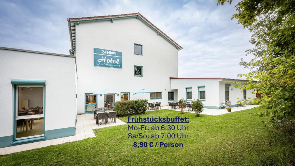 a building with a sign on the side of it at Hotel Am Wiesenweg l 24h check-in in Hausen