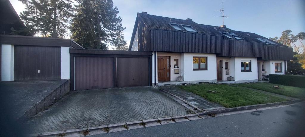 a house with a garage and a driveway at Reihenendhaus bei Nürnberg in Petersaurach