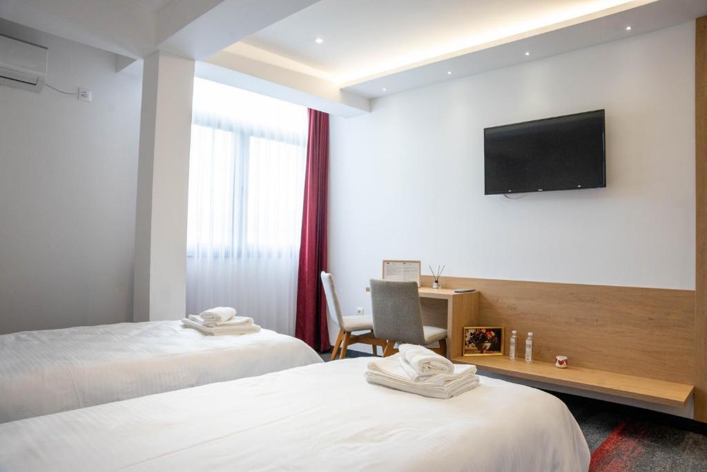 een hotelkamer met twee bedden en een flatscreen-tv bij Motel Brist in Zenica