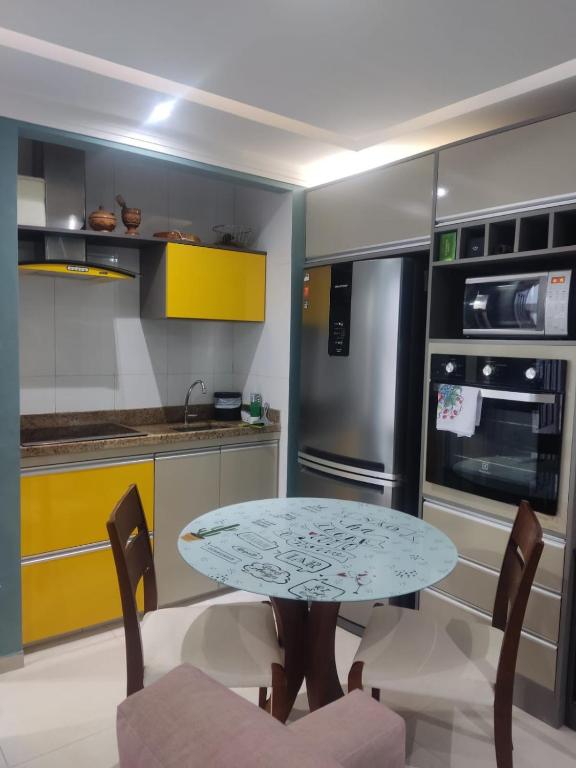 a kitchen with a table and chairs in it at Apartamento Estúdio Beira Mar in Ilhéus