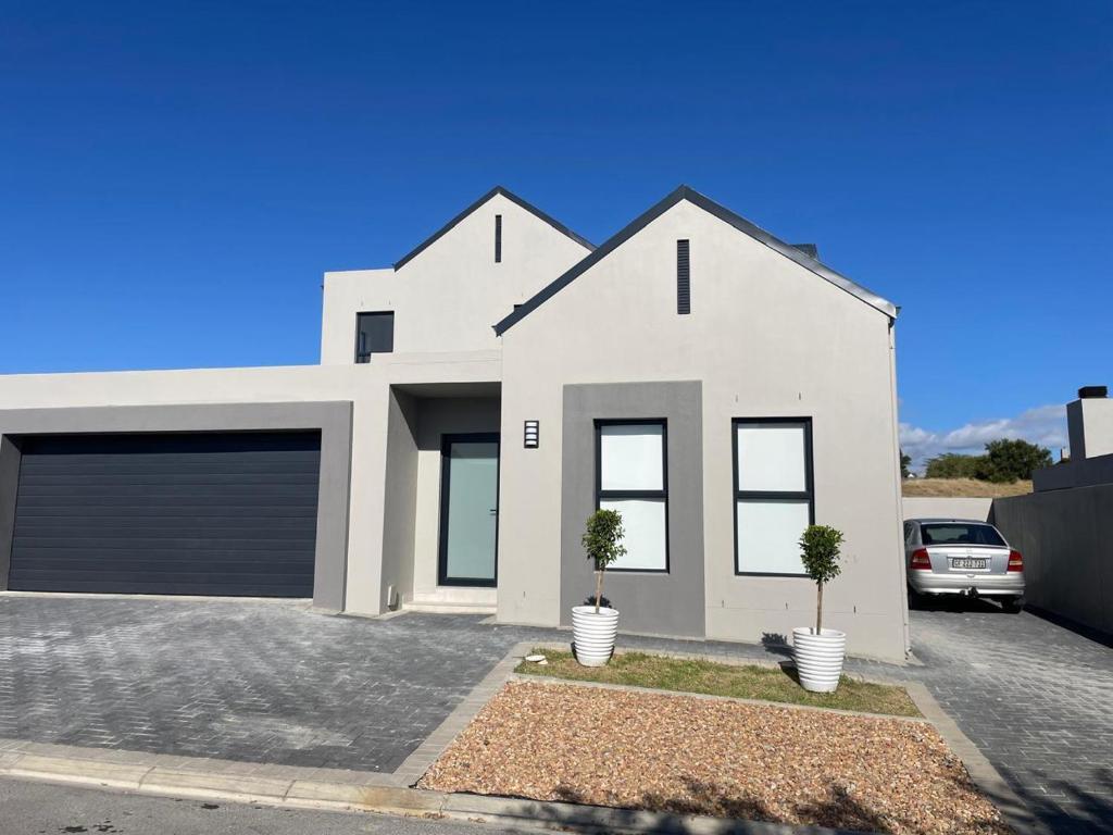 a white house with two trees in a driveway at Sunny Side Haven in Faure
