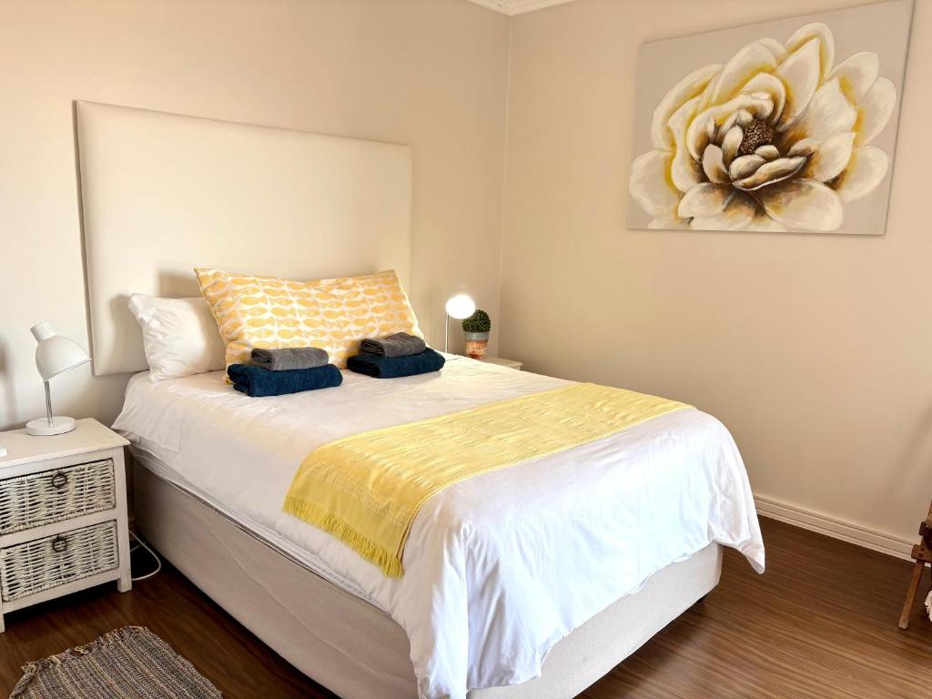 een slaapkamer met een groot wit bed met een schilderij aan de muur bij 105 Gouriqua Mosselbay in Mosselbaai