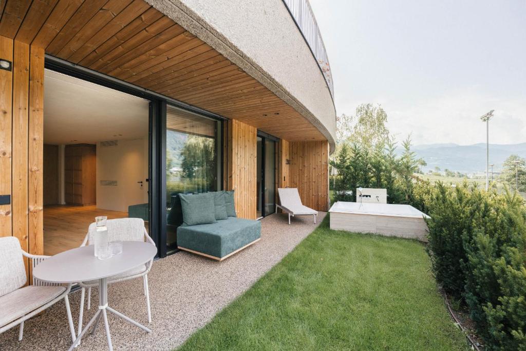 a patio with a table and chairs and a couch at Apartment Garden Loggia in Novacella