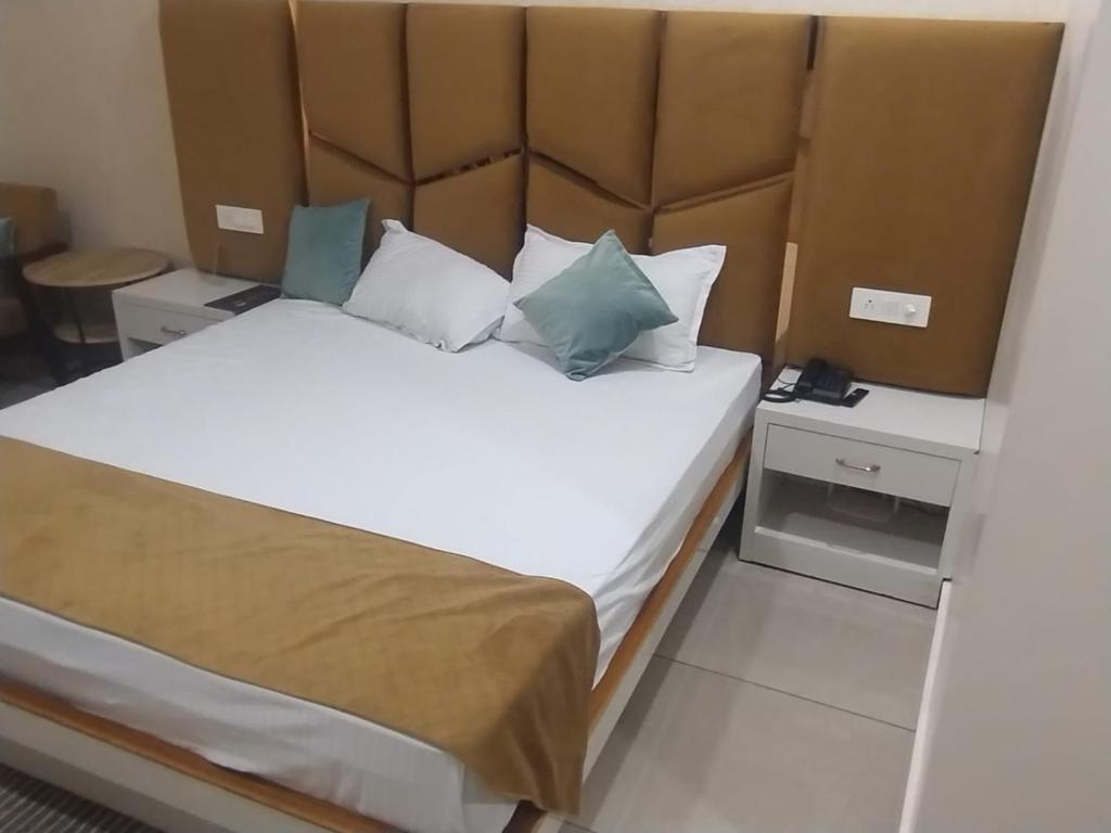 a bedroom with a large bed with a large headboard at hitkari palace in Hāpur