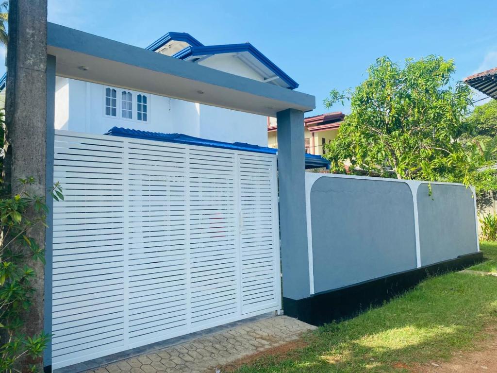 a white fence in front of a house at White N Villa in Wadduwa