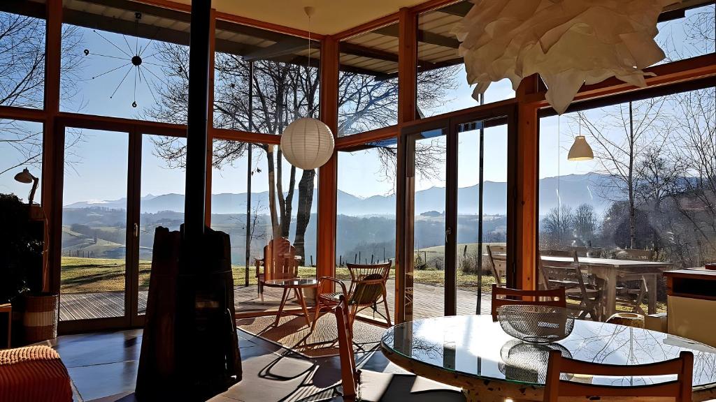 Una habitación con una mesa y sillas y una ventana grande. en Gite Dilos, en Rébénacq