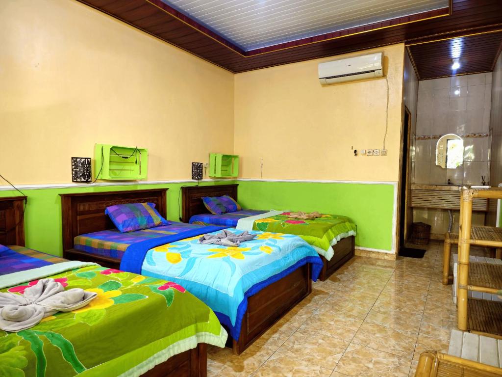 2 Betten in einem Zimmer mit Grün und Blau in der Unterkunft green view downtown in Ubud