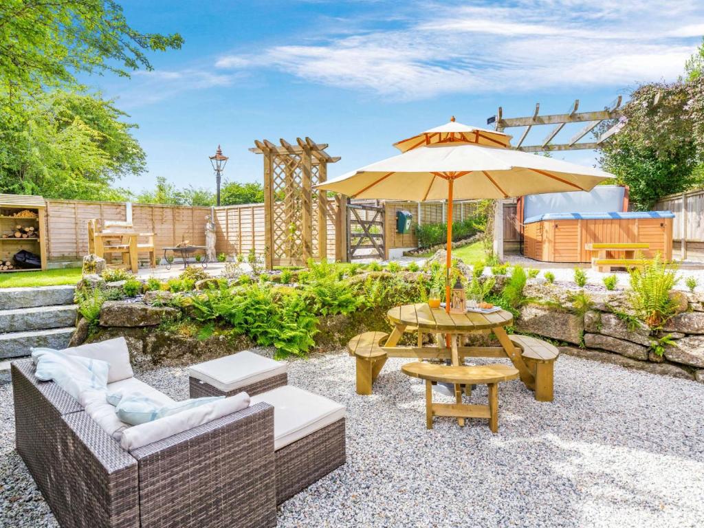 un patio con una mesa y una sombrilla en 1 Bed in Bodmin 88049, en Luxulyan