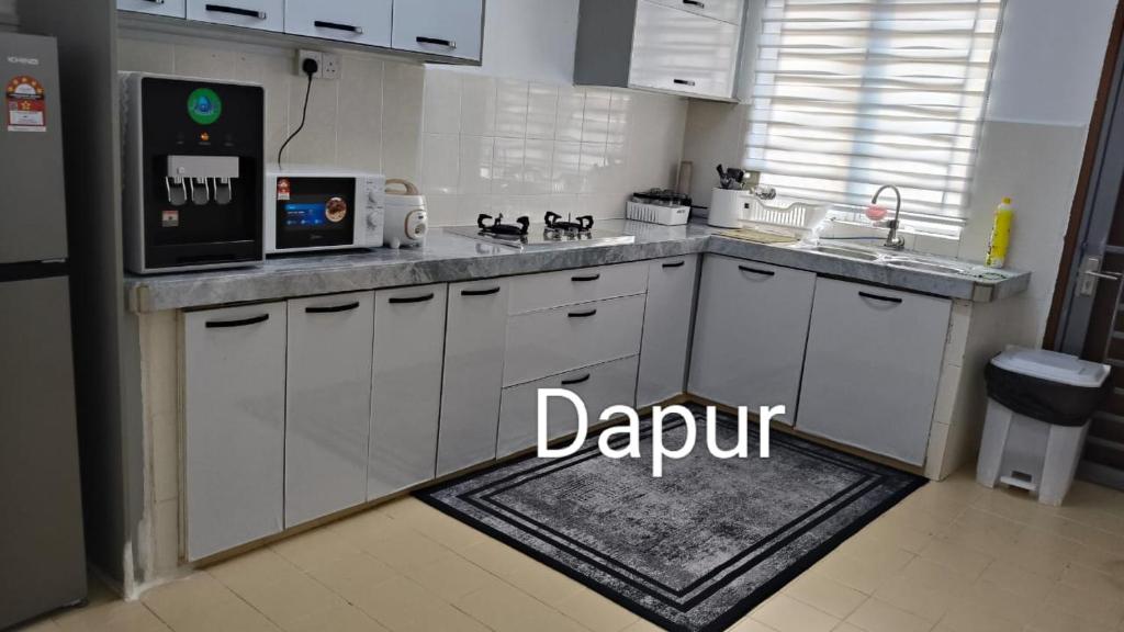 D'Raudhah Homestay : مطبخ بخزائن بيضاء وطاولة عمل