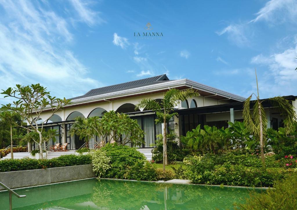 a house with a pond in front of it at La Manna Events and Leisure Place 