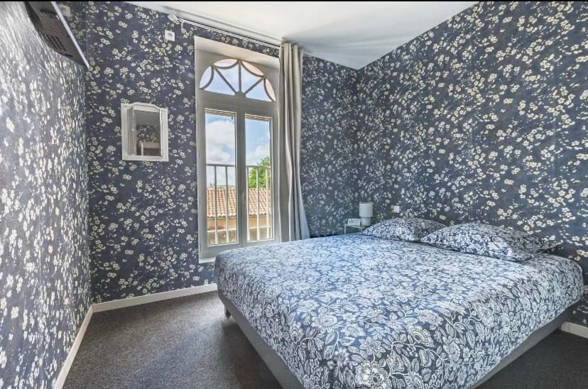 a bedroom with blue walls with a bed and a window at Le Seysses in Seysses