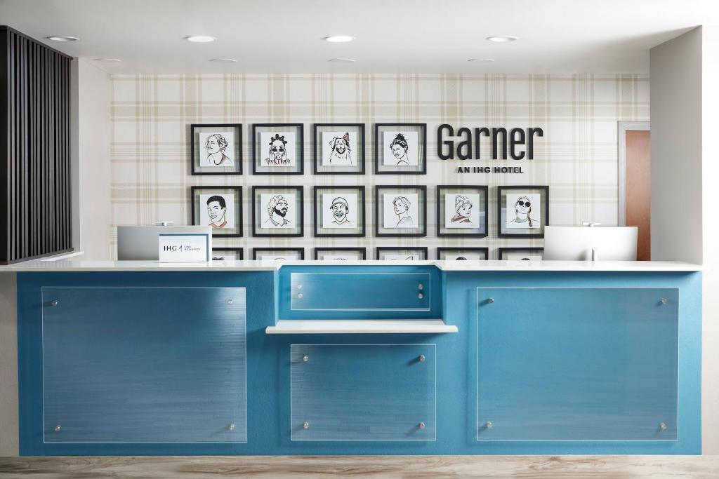 a blue counter in a store with pictures on the wall at Garner Hotel Glen Burnie BWI Airport Area by IHG in Glen Burnie