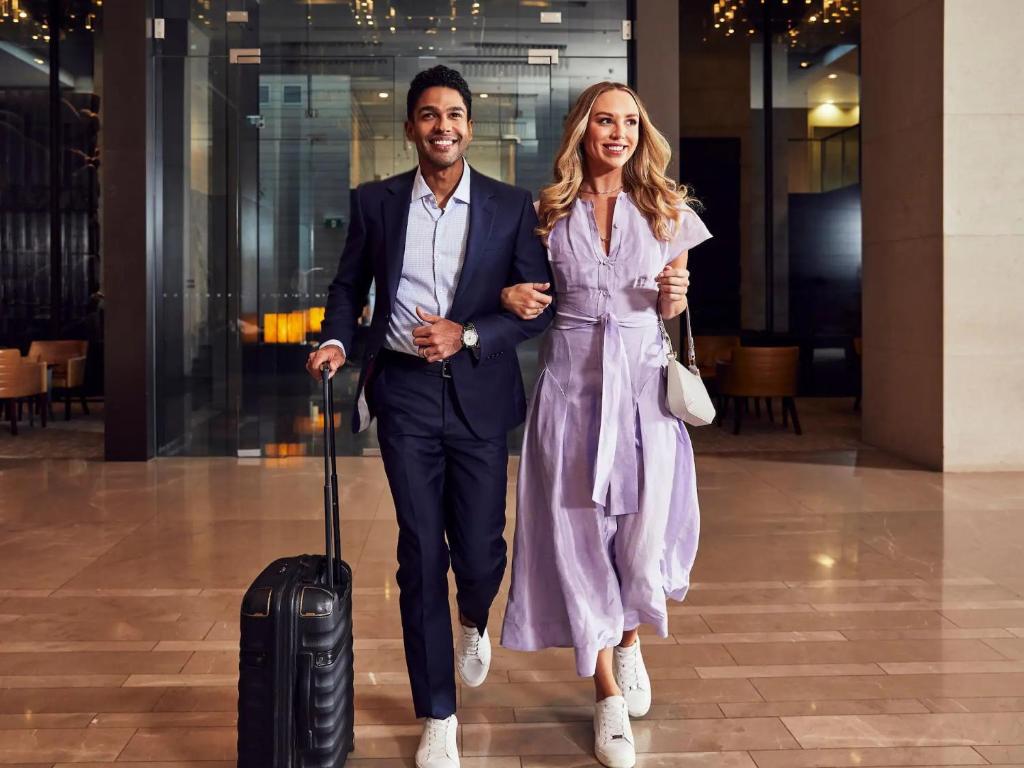 a man and a woman walking with a suitcase at The Livingston, part of JdV by Hyatt in Brooklyn
