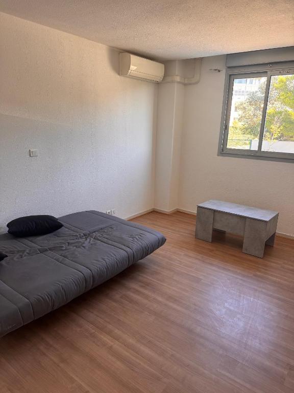 a room with a bed and a table in it at Appartement face Aéroport Marseille in Vitrolles