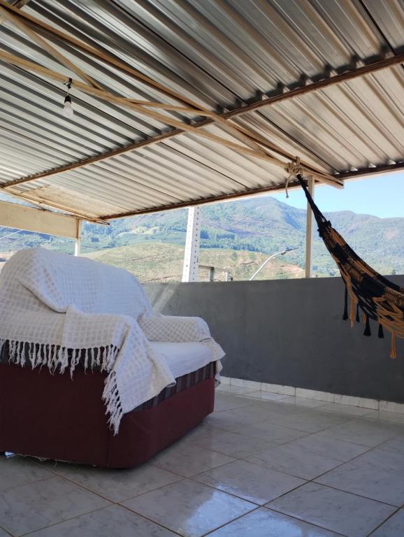 a porch with a hammock and a view of the mountains at Casa Aconchegante in Alto Caparao