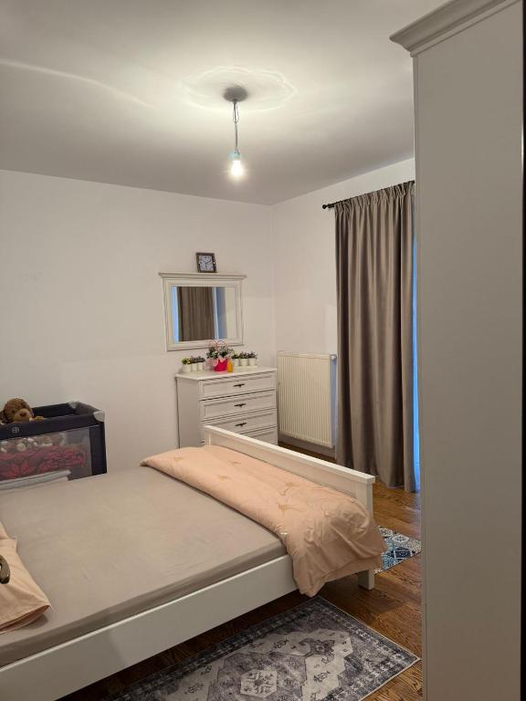 a small bedroom with a bed and a dresser at Apartament cu 2 camere in Rădăuţi