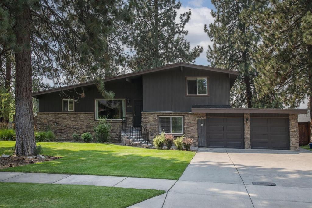a black house with a garage at Bluebird Day - Brooks House in Deschutes River Woods