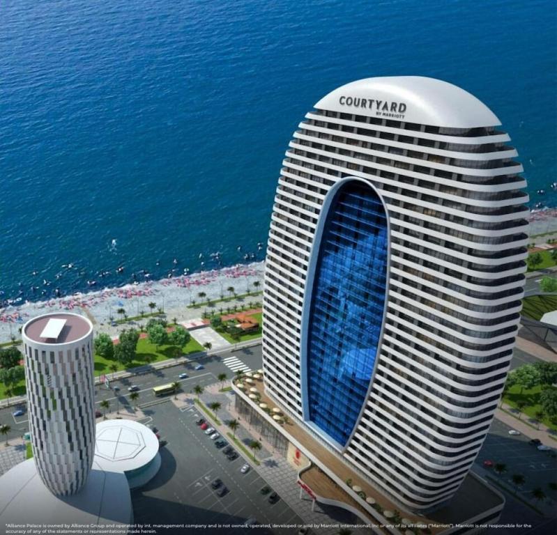a rendering of a curvy building next to the ocean at Alliance Palace In Batumi in Batumi