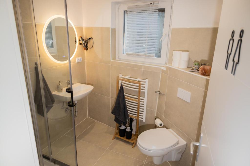 a small bathroom with a toilet and a sink at Motel Kalos in Haiger
