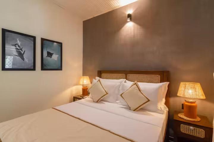 a bedroom with a white bed with two lamps and two lamps at A peaceful villa for recuperation in Ahangama