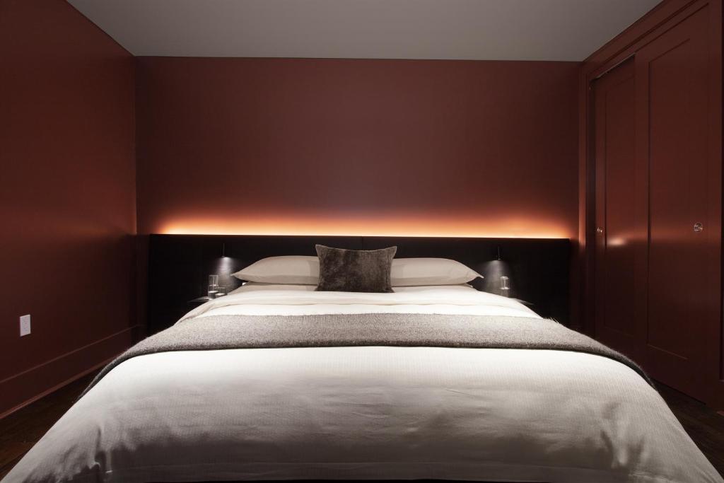 a bedroom with a large bed with red walls at The Luzianne in New Orleans