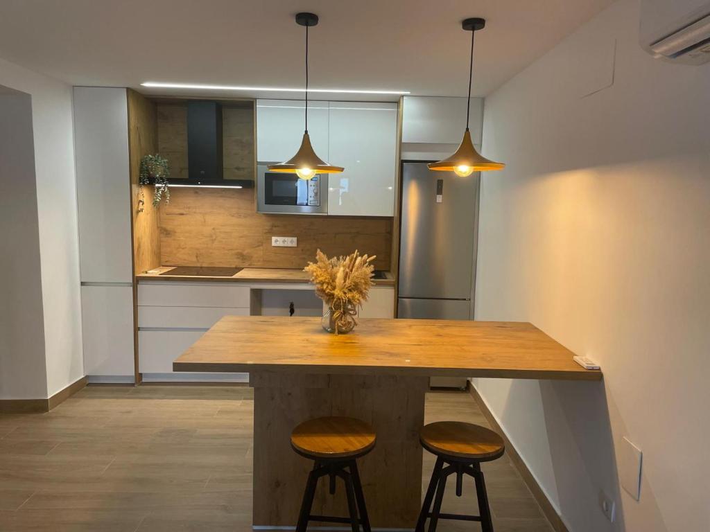 a kitchen with a large wooden table with two stools at Casa La Martinica in Almagro