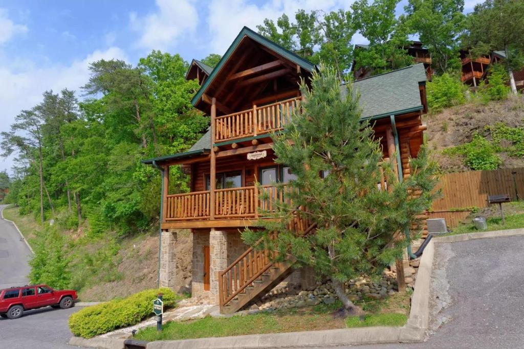 a large wooden house with a deck on a hill at Farmers Retreat #221 in Sevierville