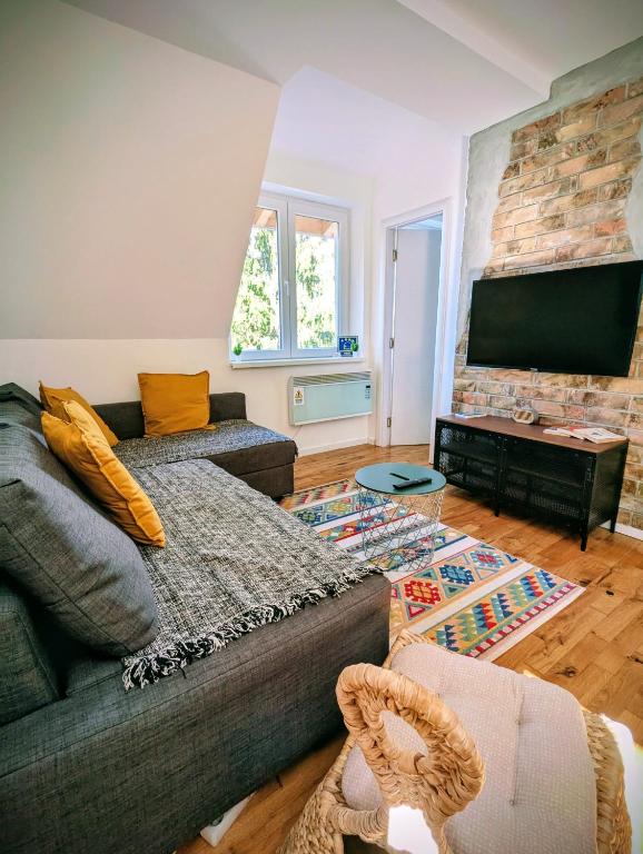 a living room with a couch and a flat screen tv at Kopaonička priča in Kopaonik