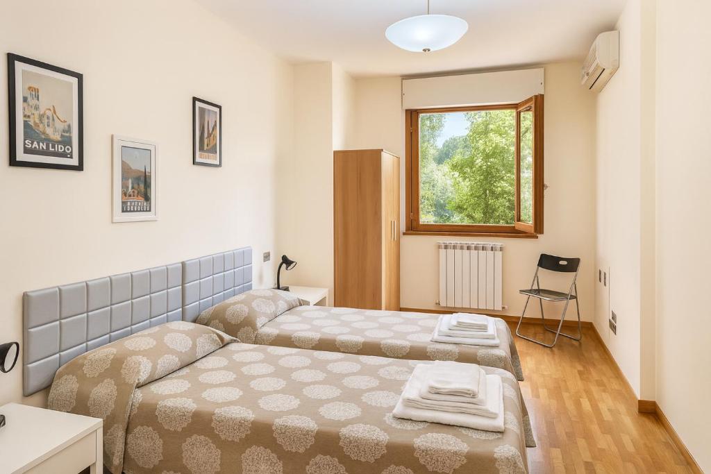 mała sypialnia z dwoma łóżkami i oknem w obiekcie Studio Sole e Residenza Luna Assisi w Asyżu