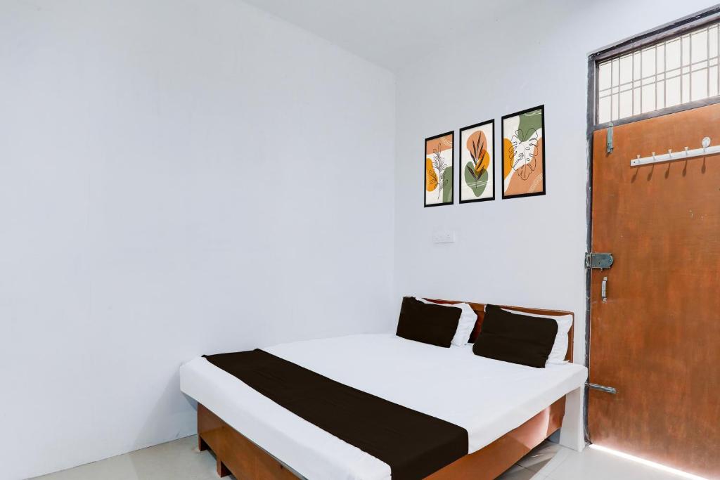 a white room with a bed and a door at Hotel O RP Hotel in Lucknow