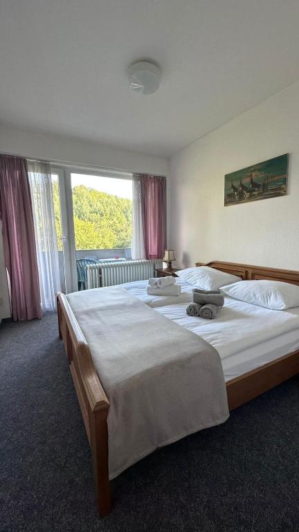 a bedroom with two beds and a large window at Wald Hotel in Kirschweiler