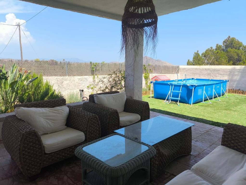 Un patio con sillas de mimbre y una mesa y una mesa azul. en Ca Leo, en Alicante