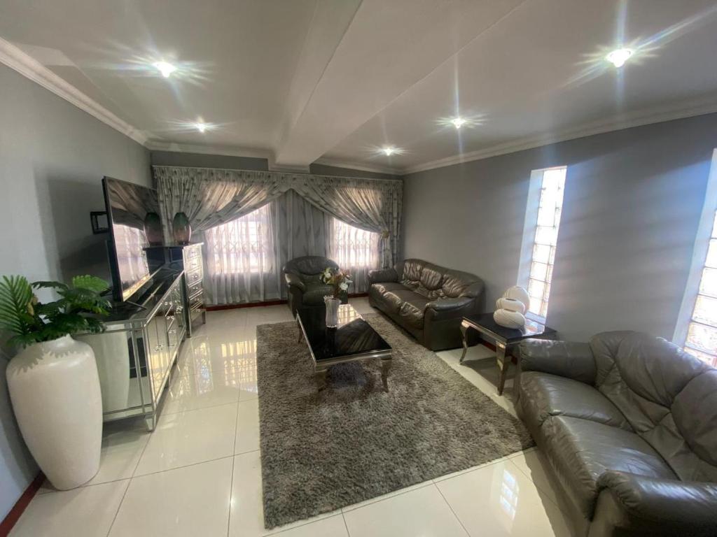 a living room with a couch and a table at Possiblerest Guesthouse in East London